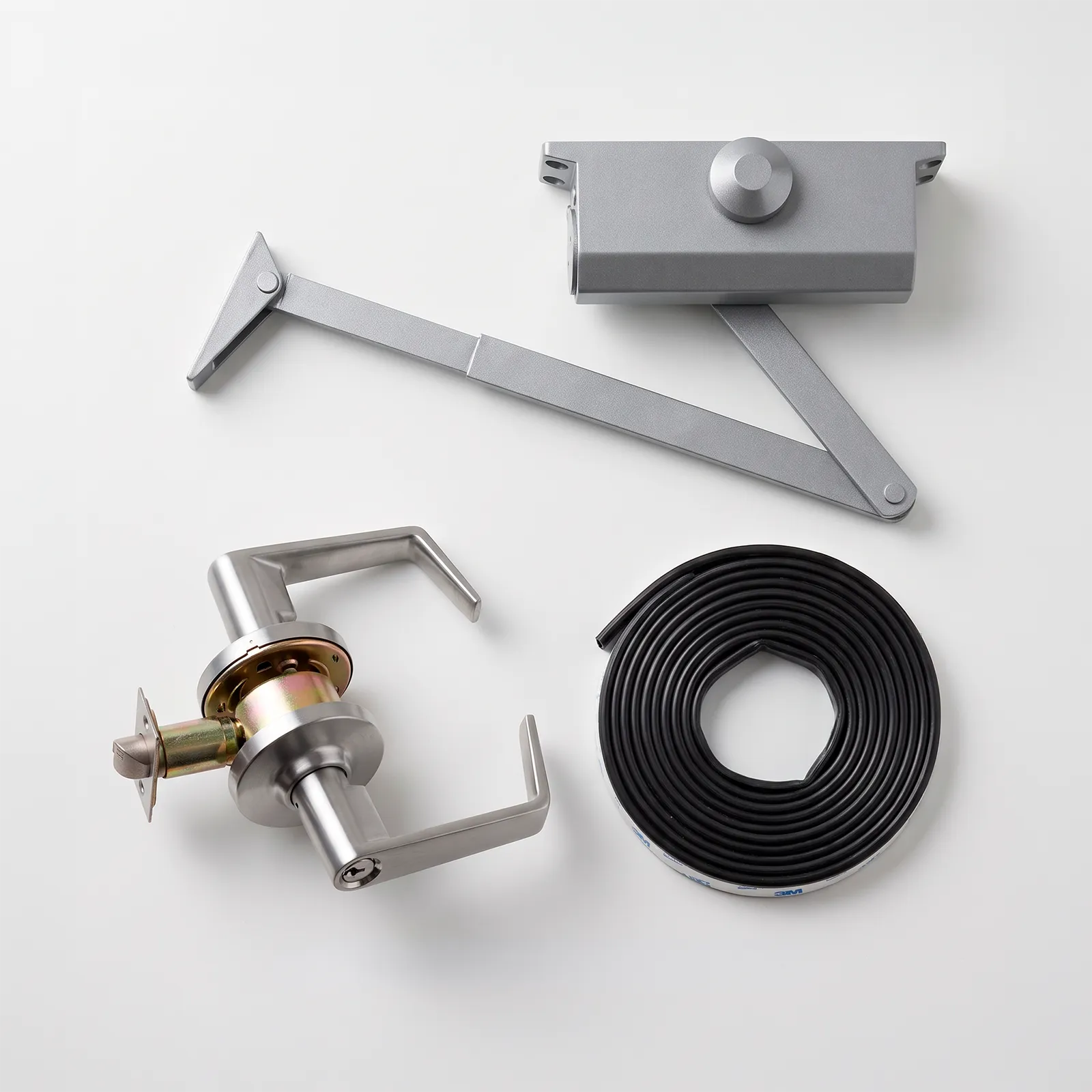 Flat-lay de herrajes premium: cerraduras ANSI, cierrapuertas F8500, cinta intumescente.